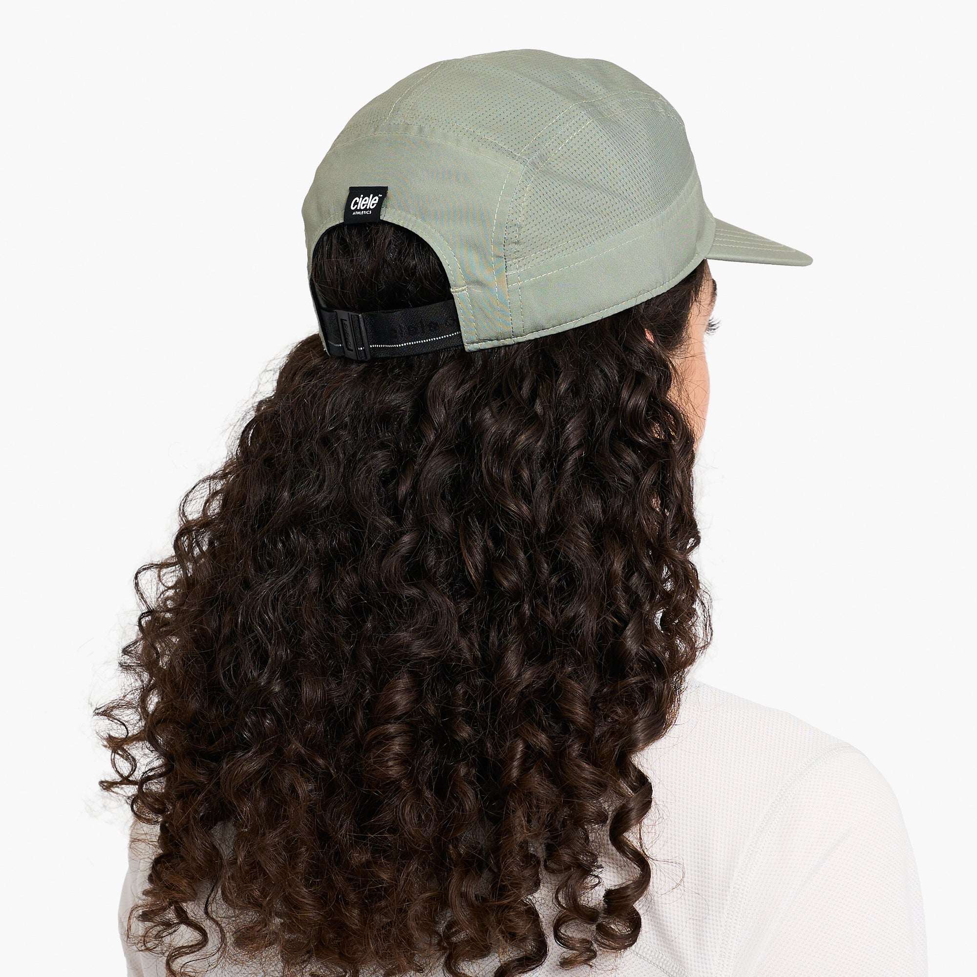 Ciele Sage green cap on model, back view with adjustable strap and mesh panel