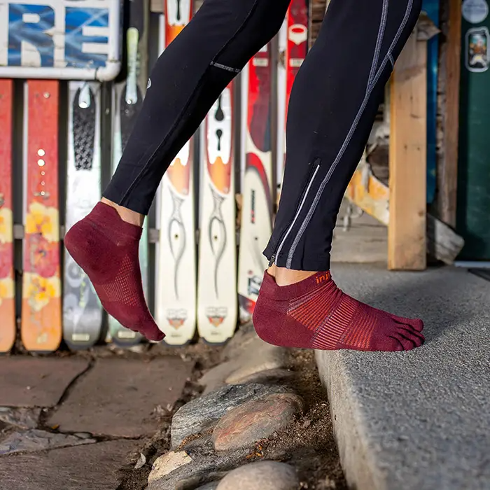 Pair of Injinji mahogany no-show toe-separator socks worn with running pants.
