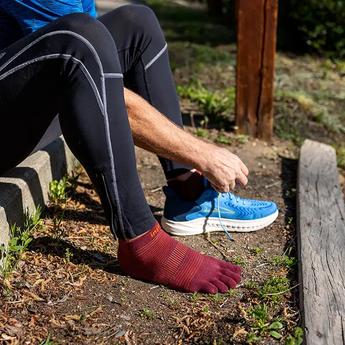 Injinji Mahogany no-show toe-separator running socks on ankles, ribbed knit detail.